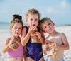 kids eating peanut butter chocolate chip cookies on the beach